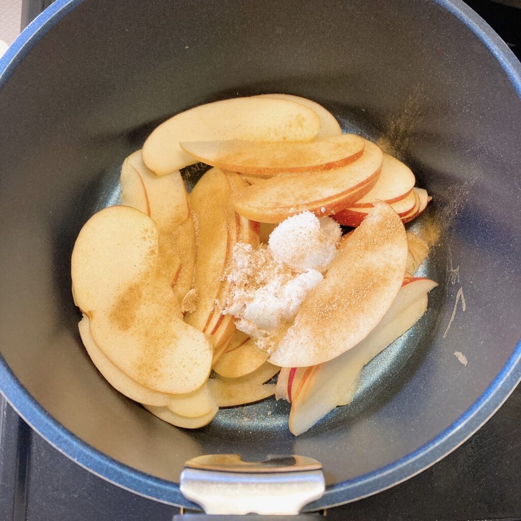 鍋に入っているスライスりんごとシナモンシュガー