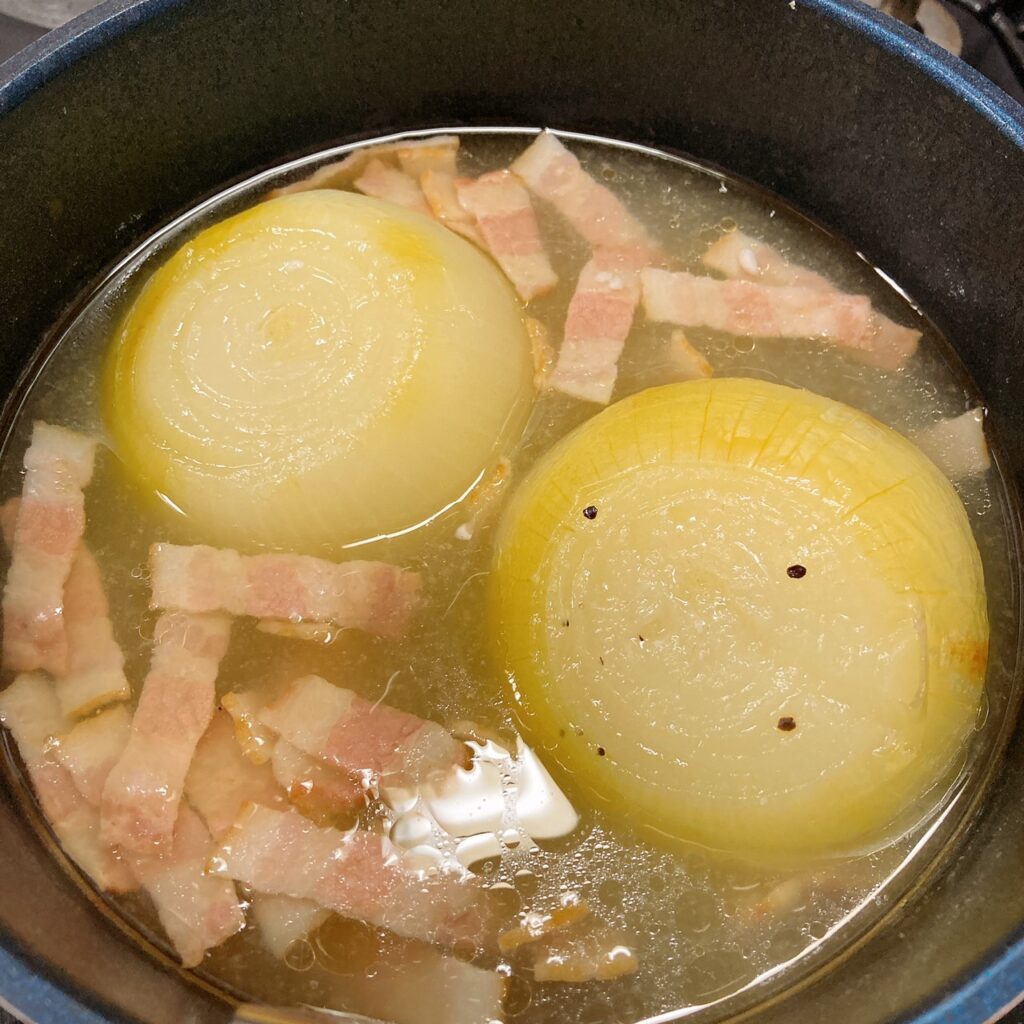 水と塩麴と生姜チューブとベーコンを煮ている鍋