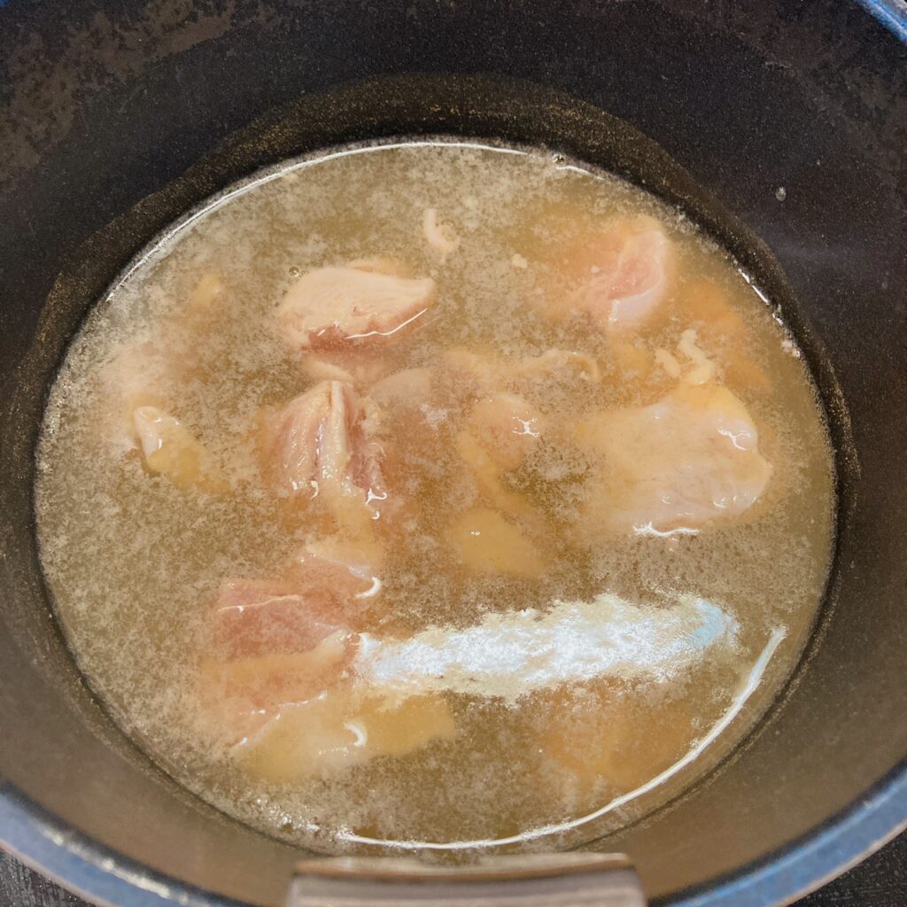 水とめんつゆと顆粒だしと鶏肉を煮ている鍋