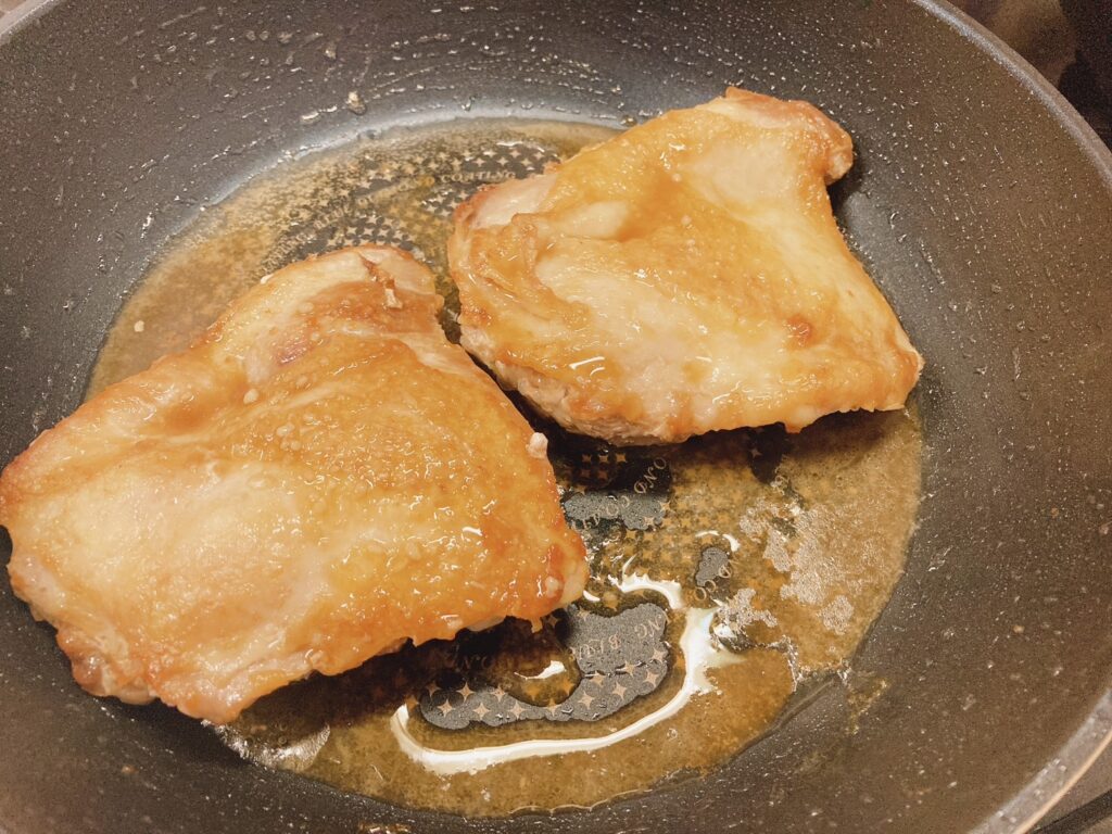 レモンソースを絡めた鶏肉を焼いているフライパン