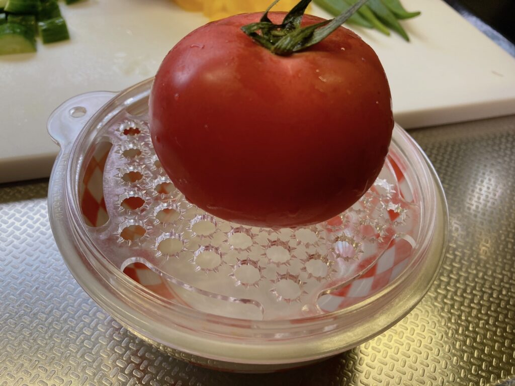 おろし器の上に載っているトマト