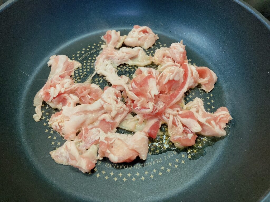 フライパンで炒めている豚バラ肉