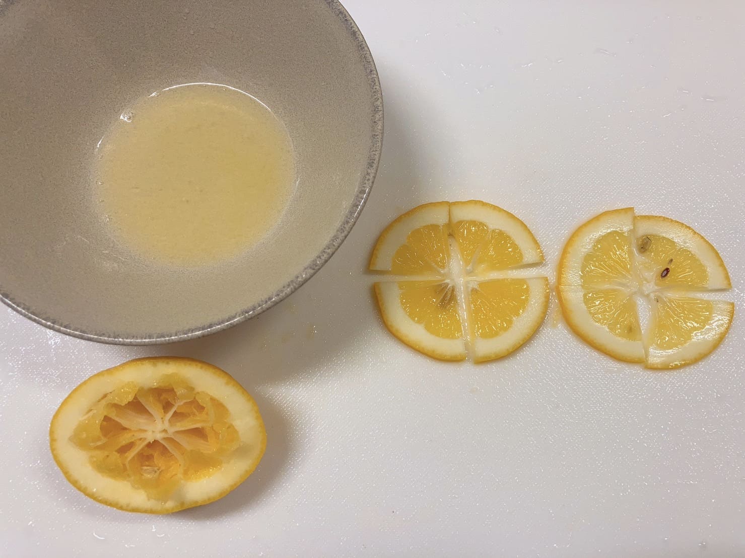 絞ったレモンと、スライスして4等分に切ったレモン